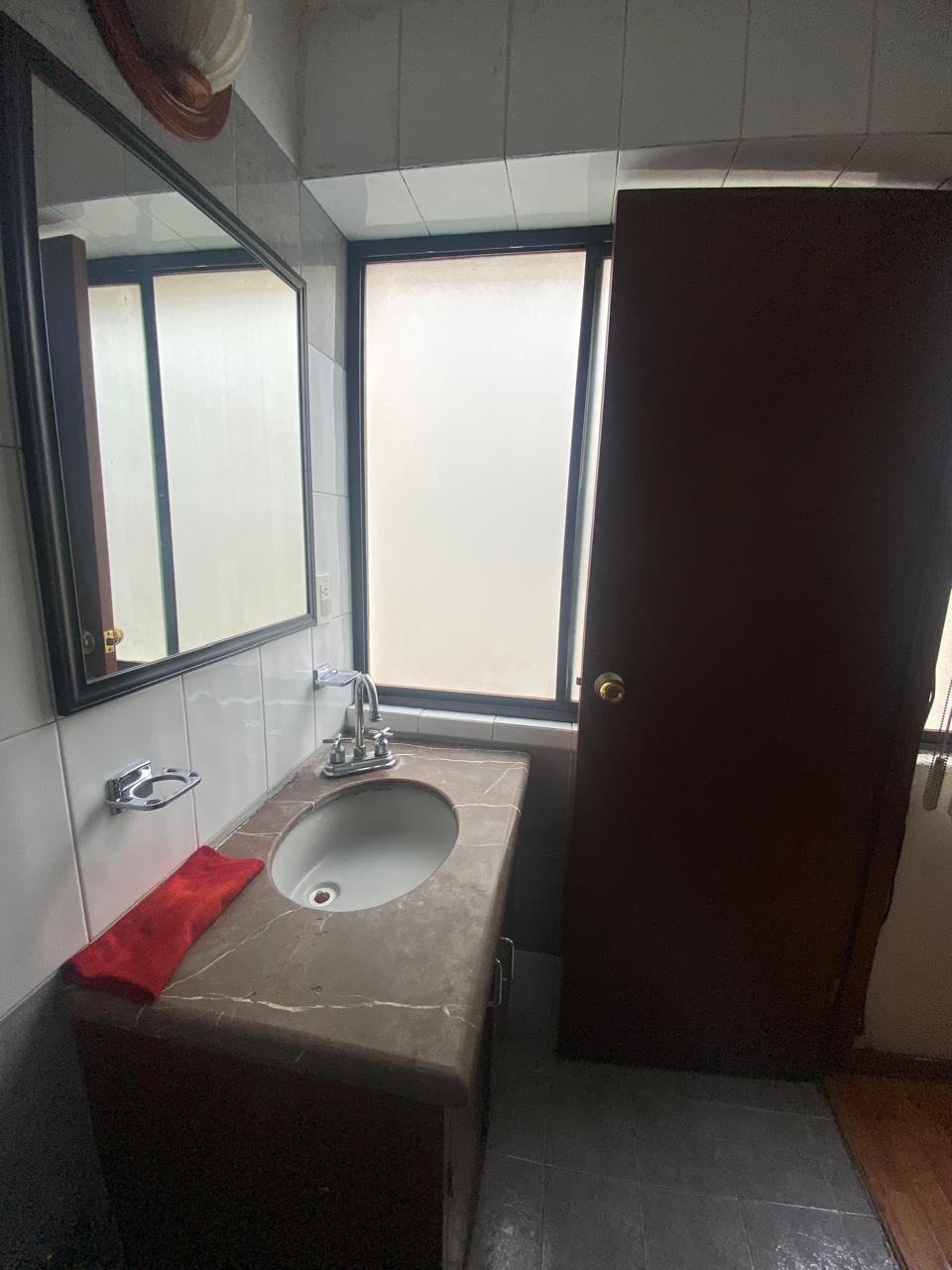 Baño privado con lavabo de mármol y espejo