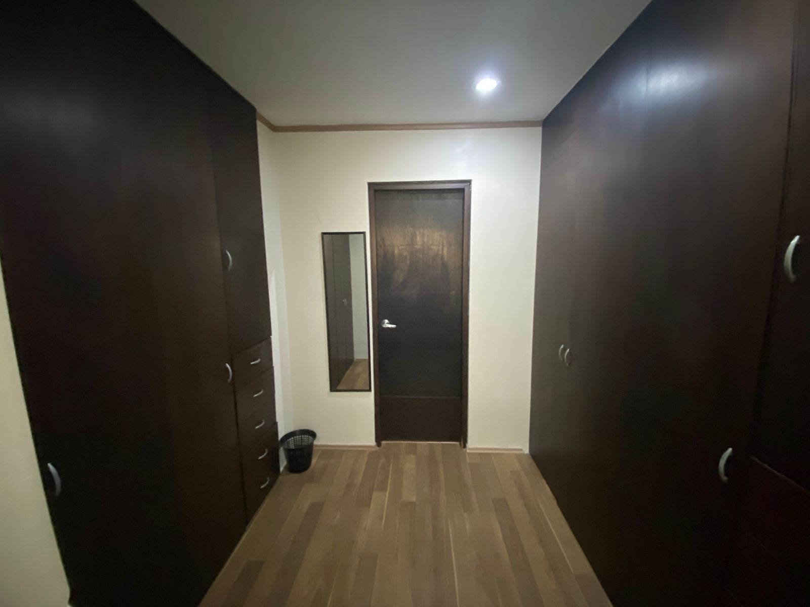 Clóset empotrado de madera oscura con espejo