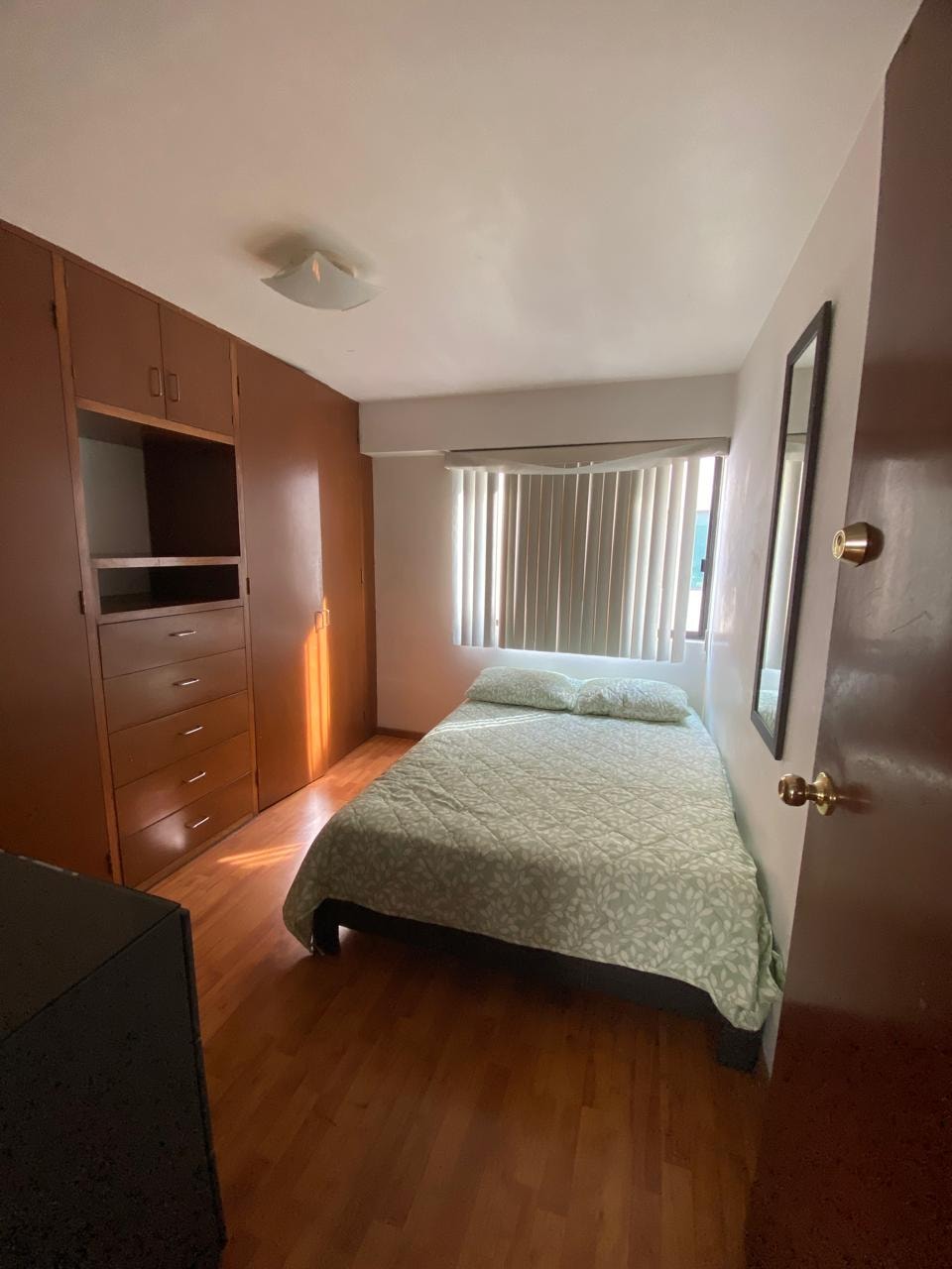 Habitación con muebles de madera y persianas